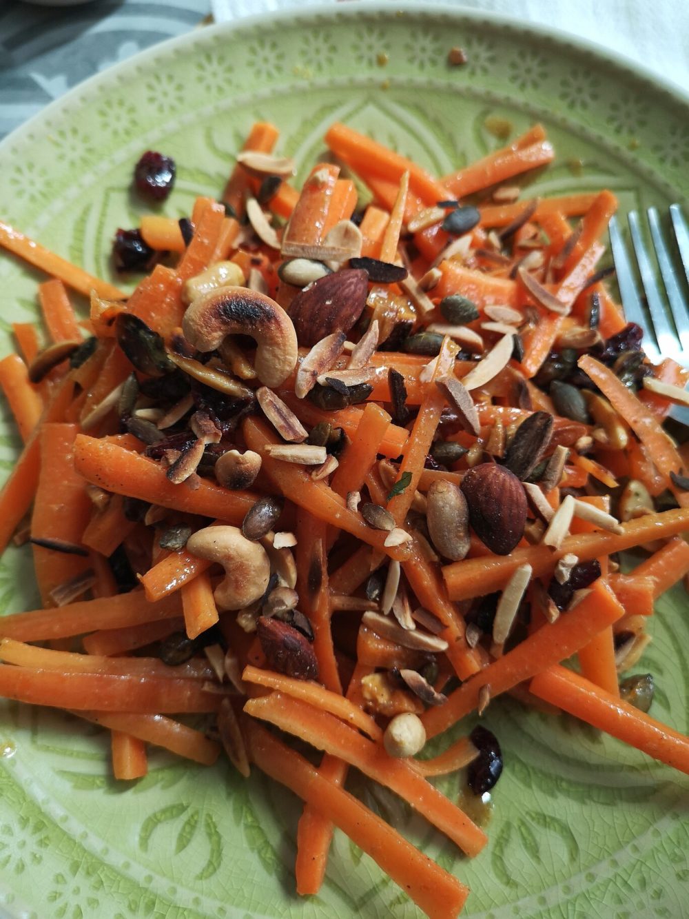 moroccan carrot salad on a green plate with a fork