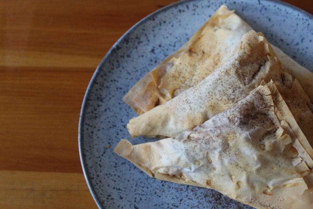 vegan apple pie turnovers on a speckled plate on a wooden table