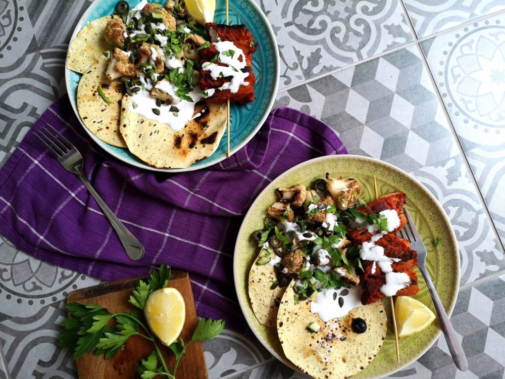 lebanese style chick-un saslik with charred lemon cauliflower salad on two plates