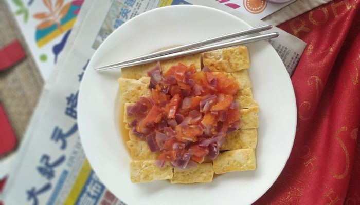 vegan chinese "egg" and tomato on a white plate