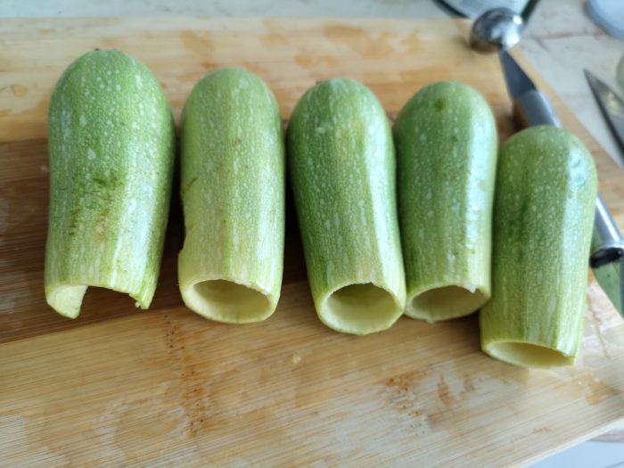 hollowed zucchini pieces on a cutting board