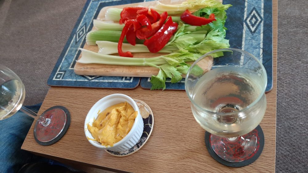 Cashew Queso in a white dish in front of chopped vegetables