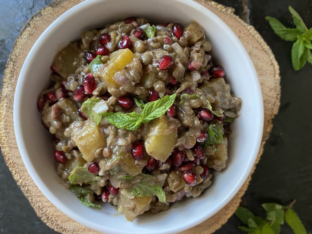 beet lentil salad in a white dish against a brown and black background