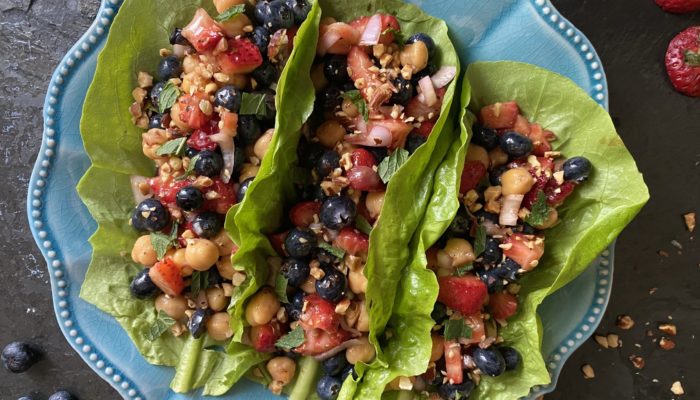 chickpea lettuce wraps on a blue plate against a black background