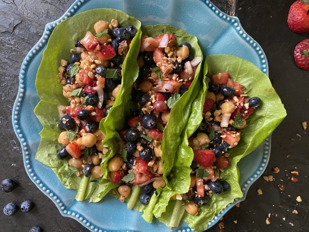 chickpea lettuce wraps on a blue plate against a black background