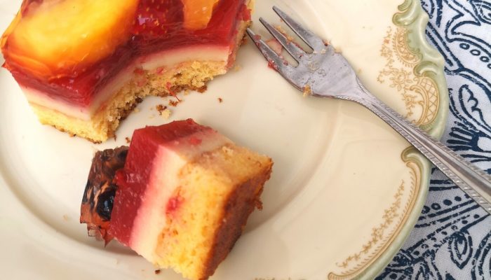 summer fruit cake bars on a white plate with a fork