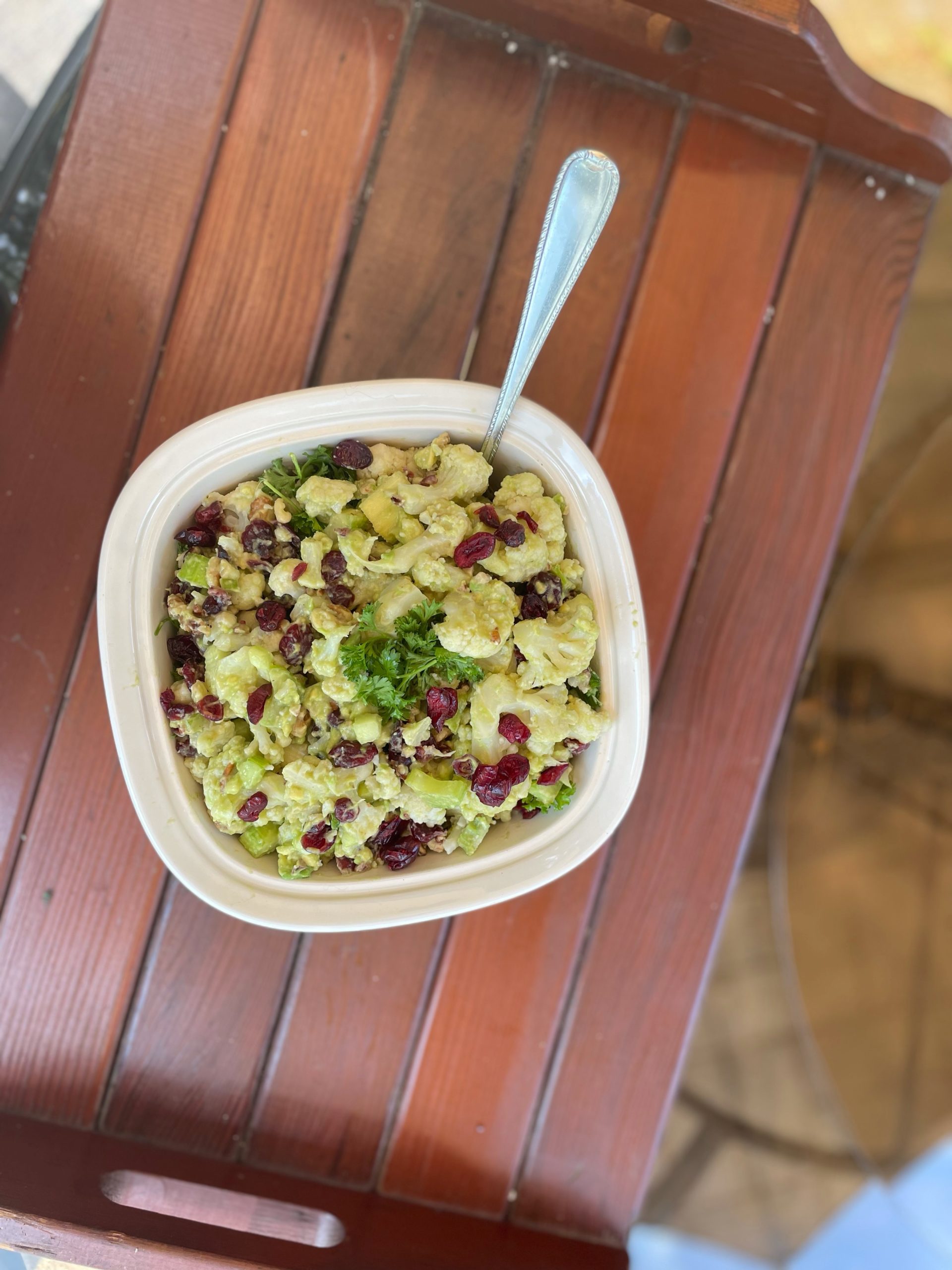 creamy cauliflower salad in a serving bowl on a table