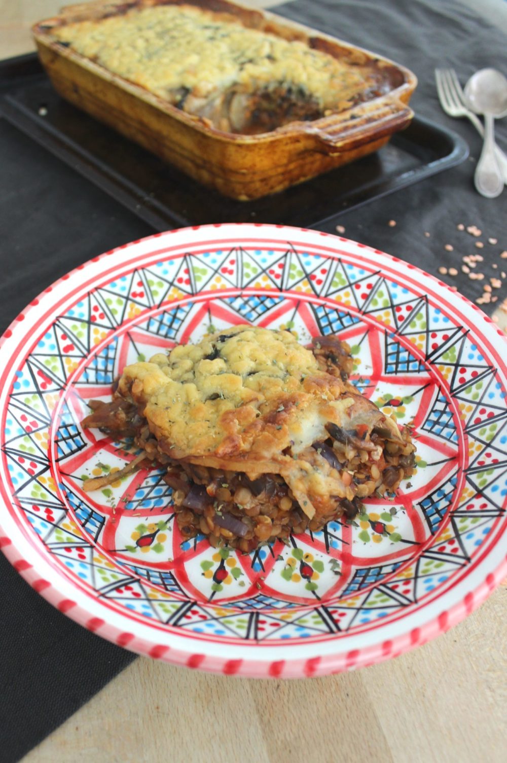 moussaka on a plate with a pan in the background