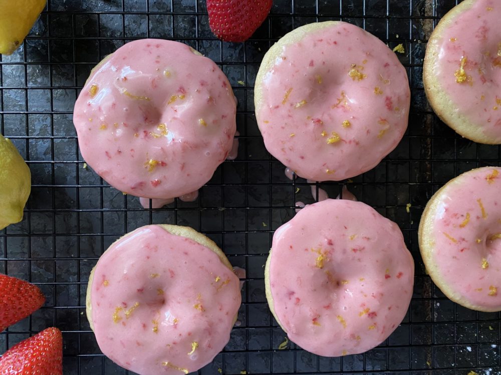 vegan strawberry lemon donuts on a black cooling rack