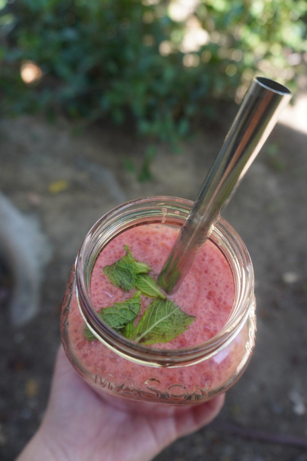 watermelon agua fresca bubble tea in a glass with a metal straw