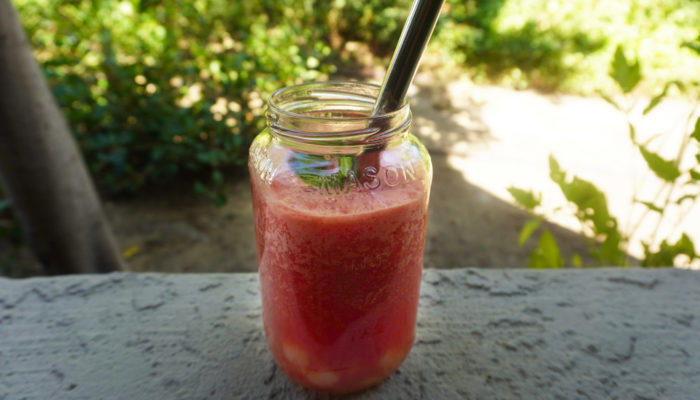 watermelon agua fresca bubble tea in a glass with a metal straw outside