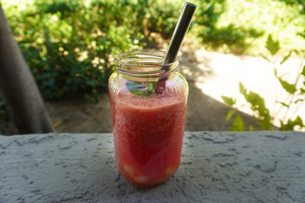 watermelon agua fresca bubble tea in a glass with a metal straw outside