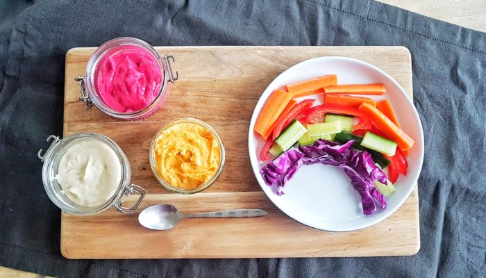 rainbow dip and vegetables on a wooden tray