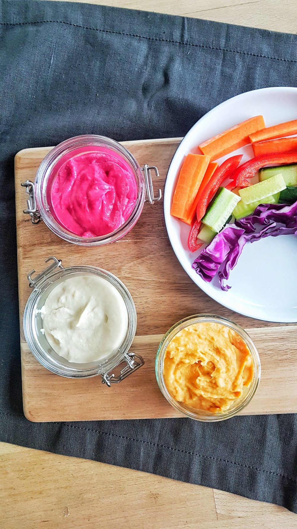 rainbow dip and vegetables on a wooden tray