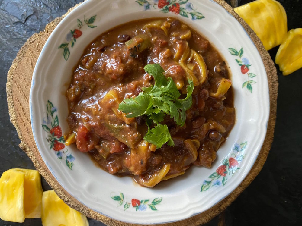 jackfruit chili in a decorative bowl against a black background