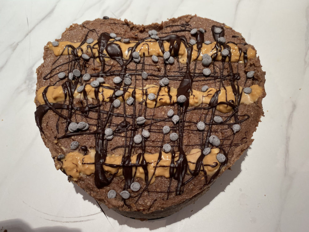 raw vegan cheesecake with peanut butter drizzle and chocolate chips