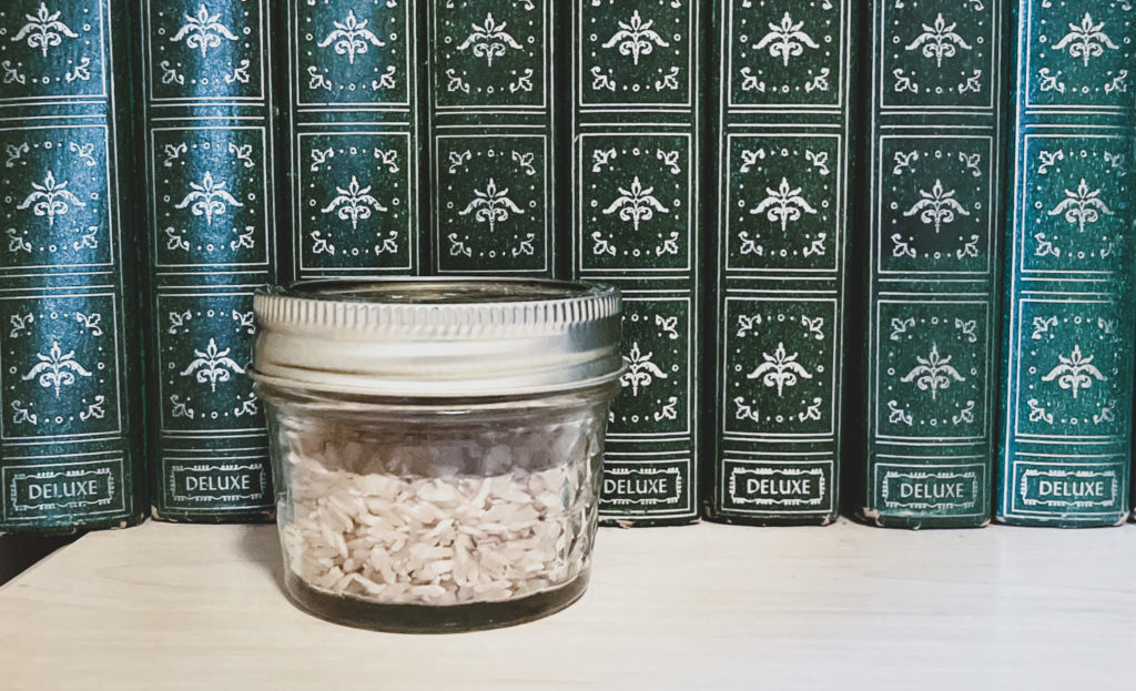 mason jar with rice in front of books