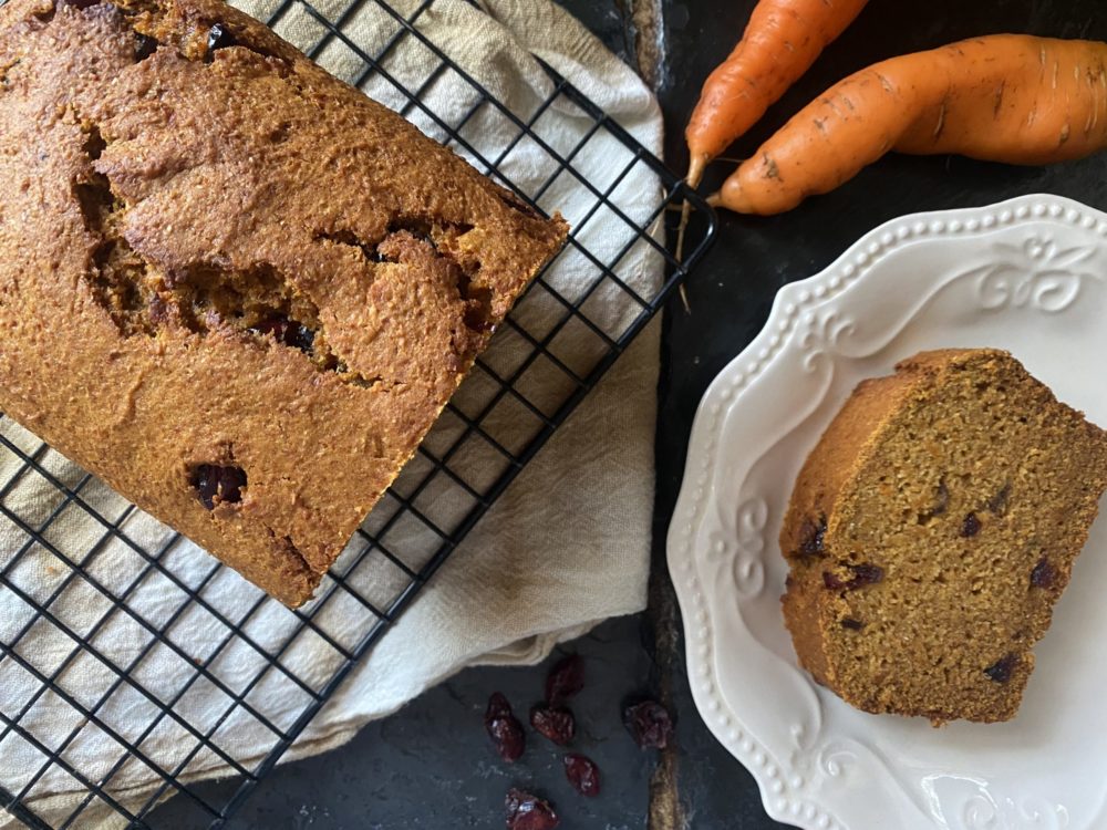 a loaf and slice of vegan carrot cranberry bread