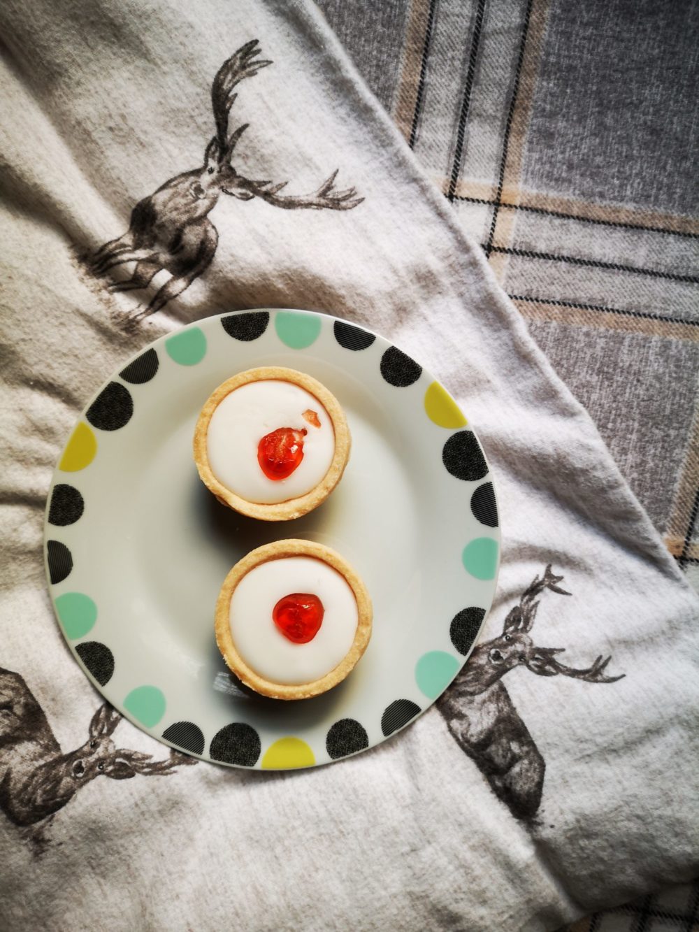 two mini cherry tarts on a decorative plate