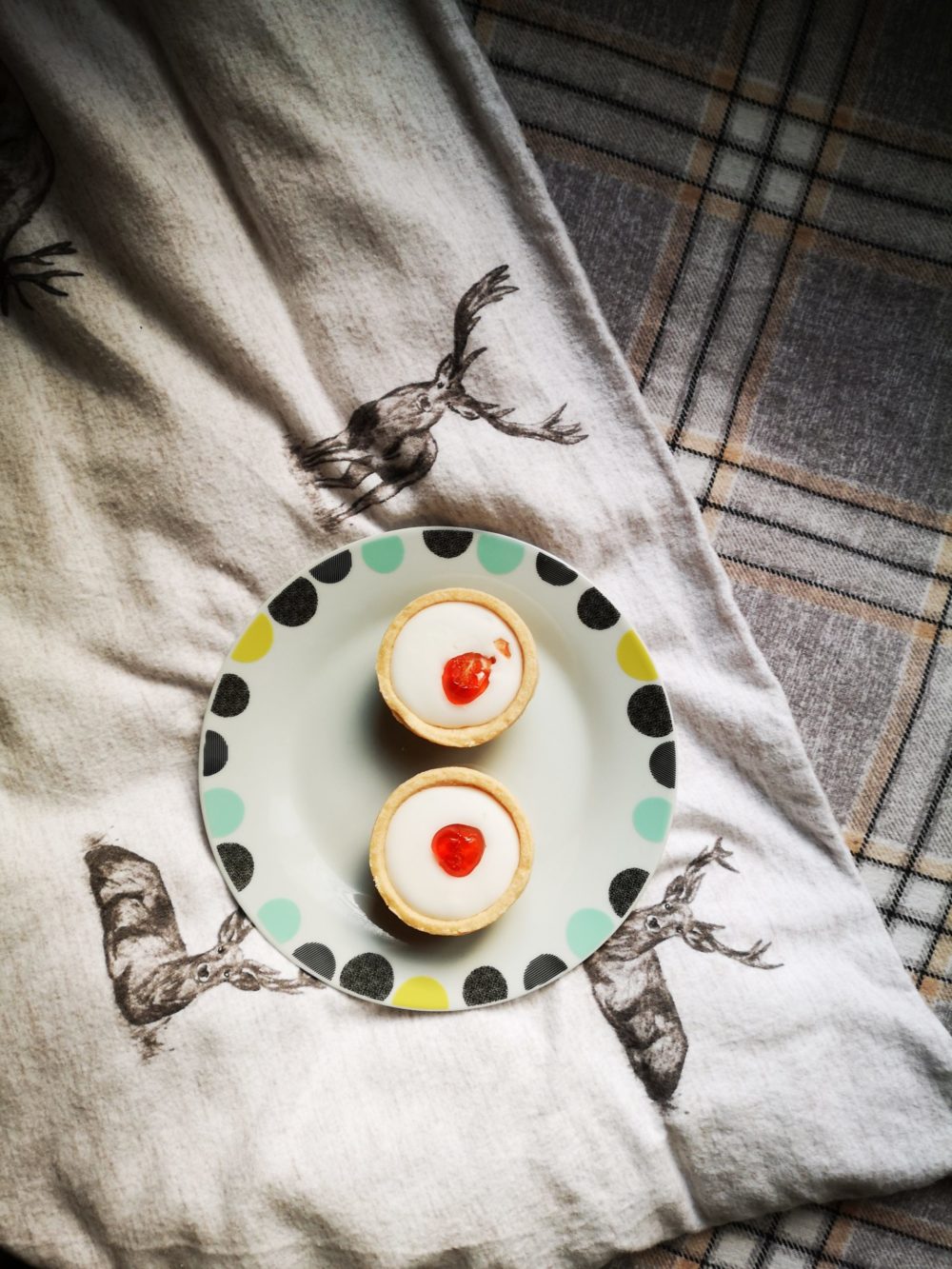 two mini cherry tarts on a decorative plate