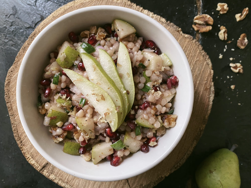 pomegranate pear couscous salad with dark background