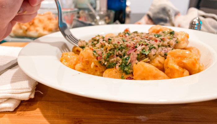 butternut squash gnocchi with chimichurri topping on a white plate with a fork