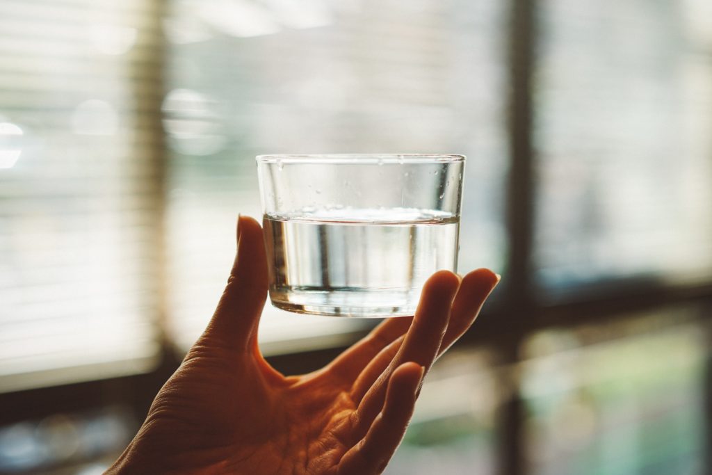 Hand holding glass of water