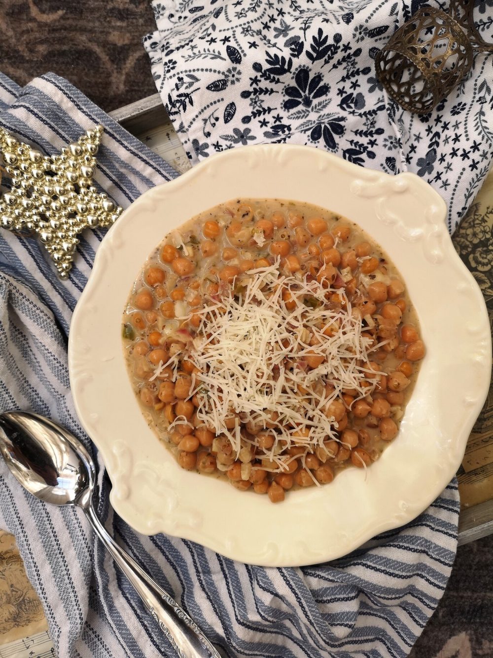 vegan cacio e pepe in a white dish next to decorative towels and a spoon
