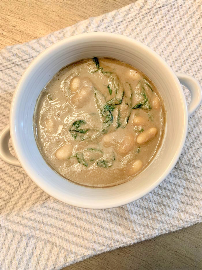cannellini spinach mushroom soup in a white dish