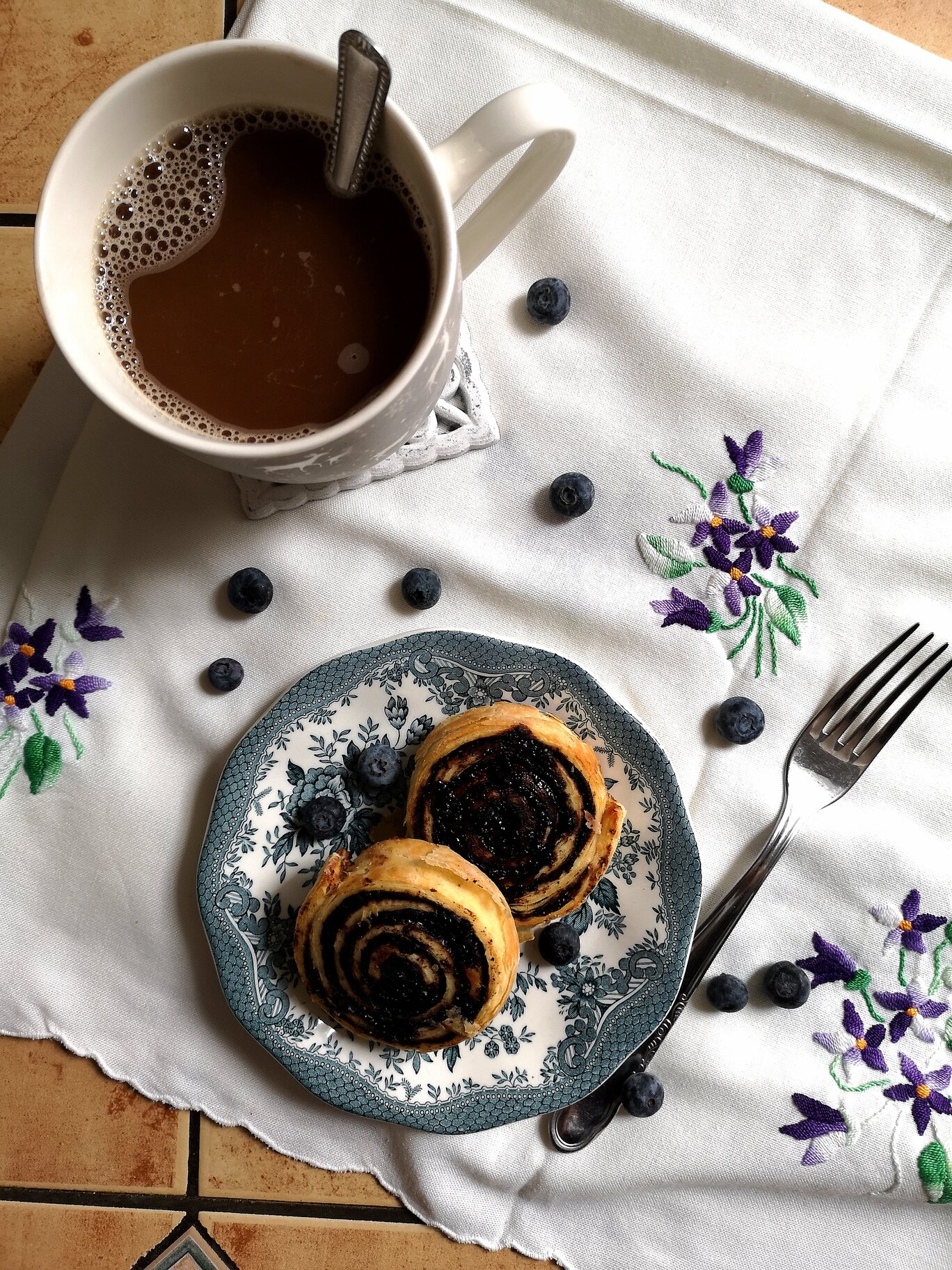 hungarian cocoa rolls on a plate next to a fork and a mug