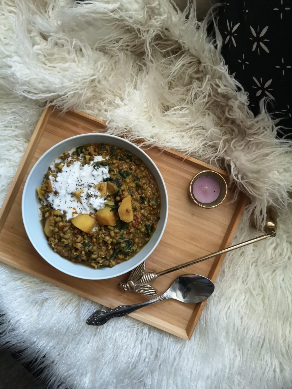 mung bean stew in a white bowl with a spoon