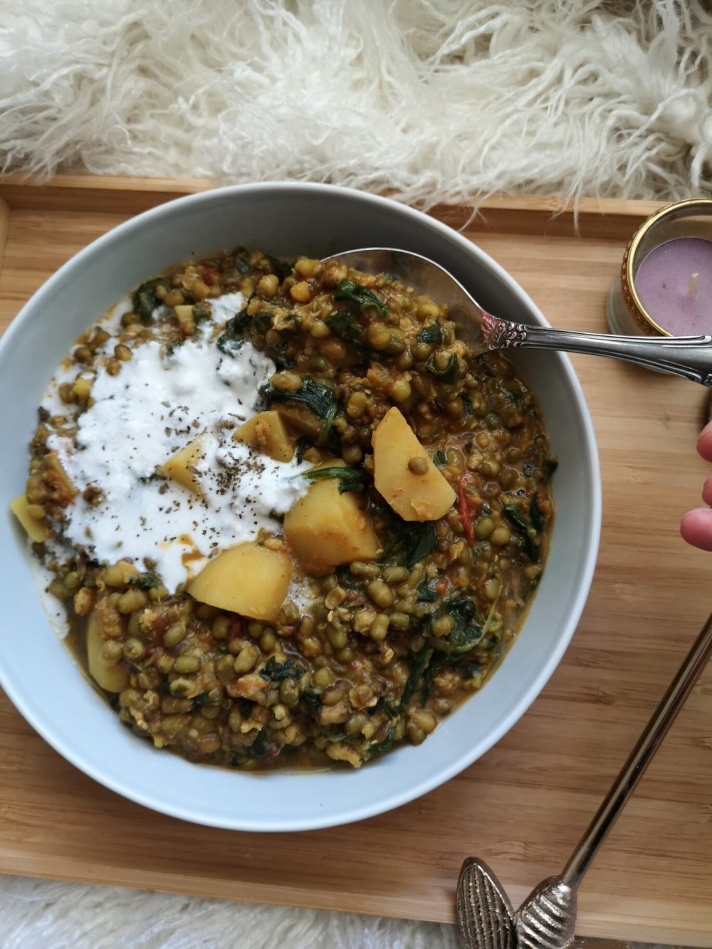 mung bean stew in a white bowl with a spoon