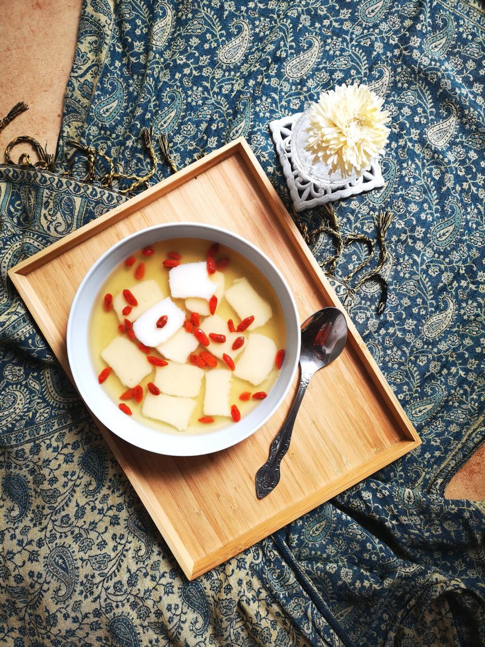 zhuniangao in a white dish on a wooden tray with a spoon