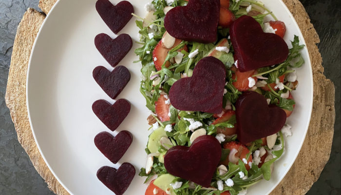 beet salad on a white plate with brown and black background