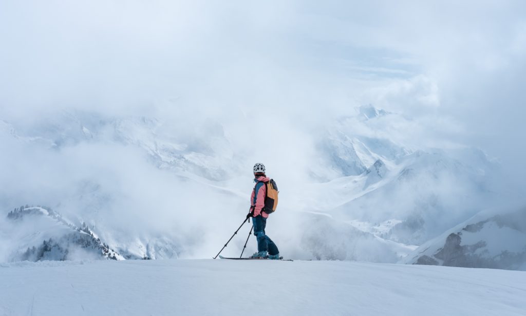 Skiier looking at a cloud covered mountain