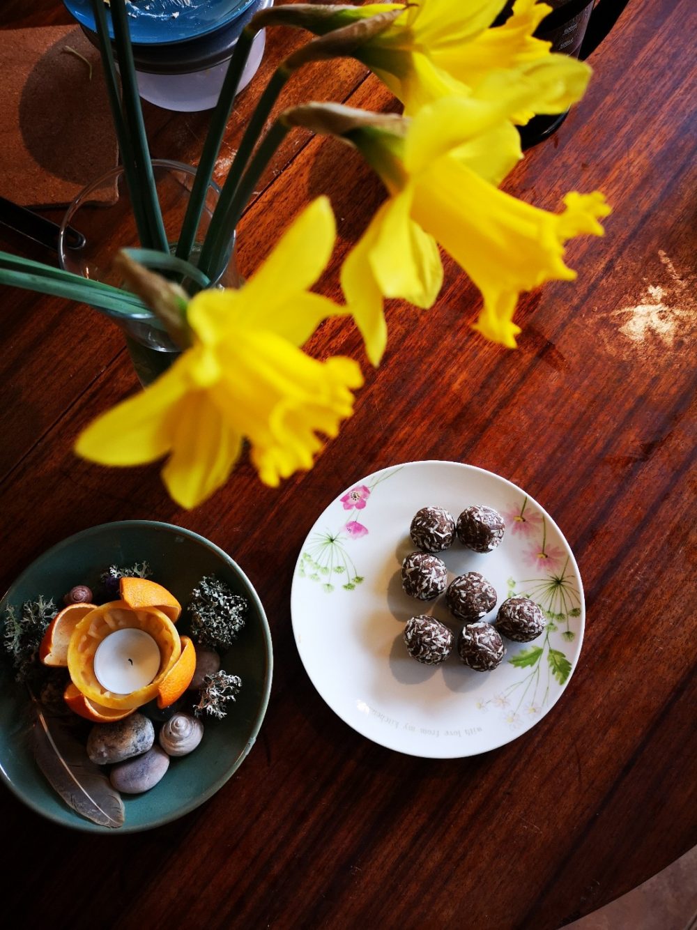 carob energy bites on a floral plate on a table top with daffodils