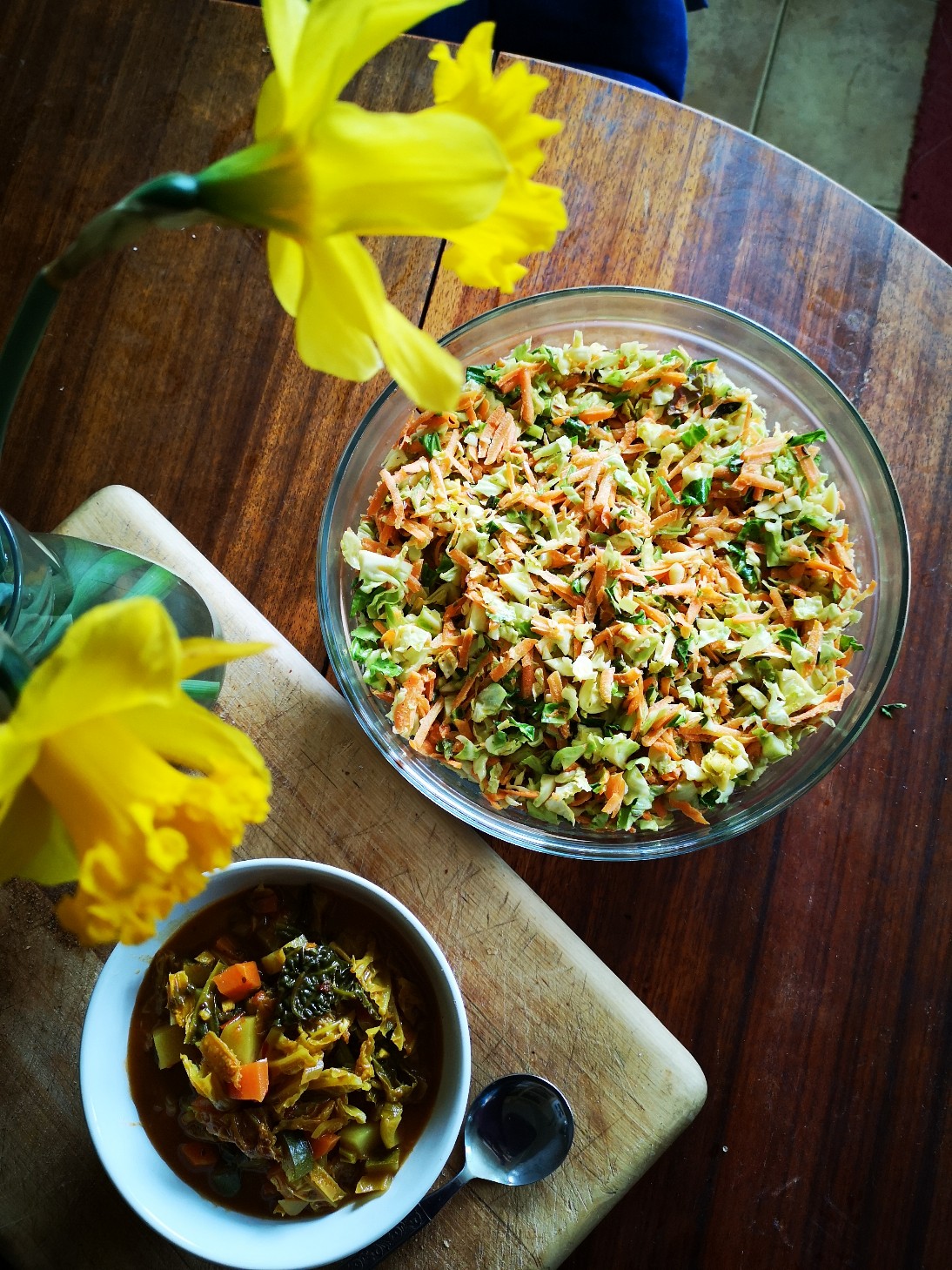 vegan spring garden subji in a white dish on a table with flowers