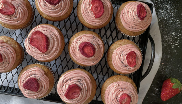 vegan strawberry poppy cupcakes on a black cooling rack