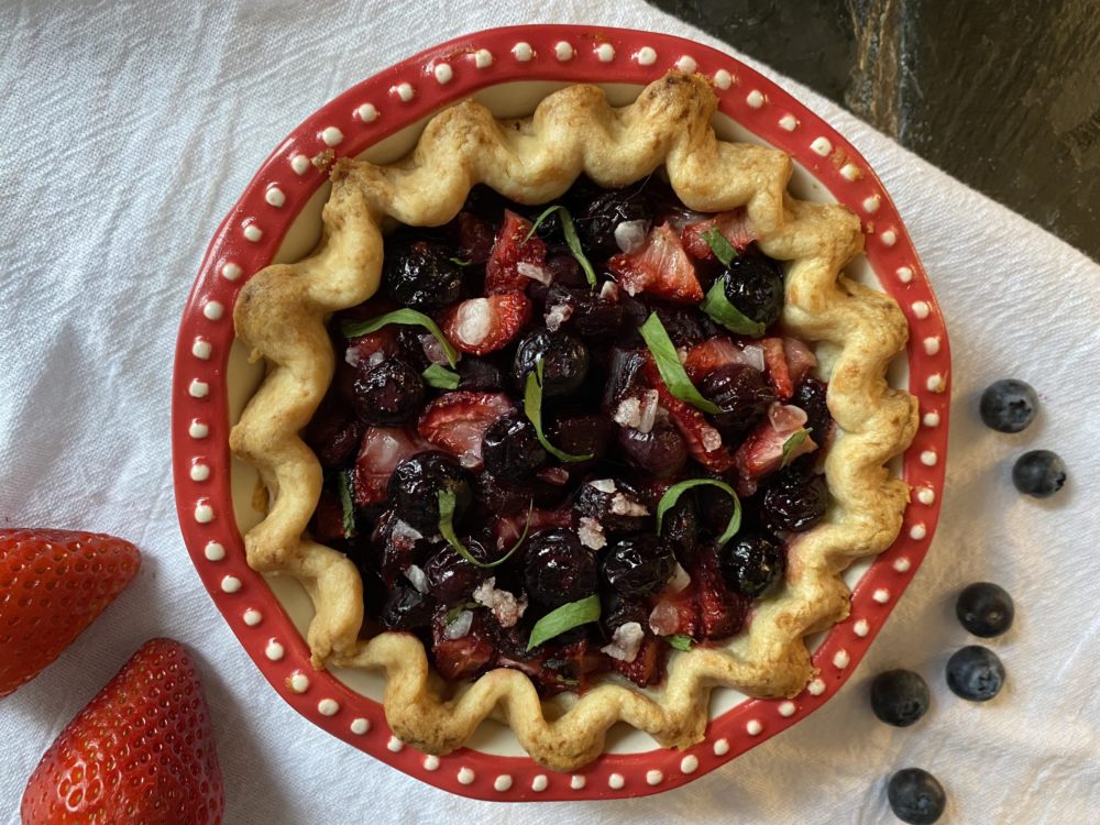 balsamic beet berry pie in a red and white dish next to a few berries