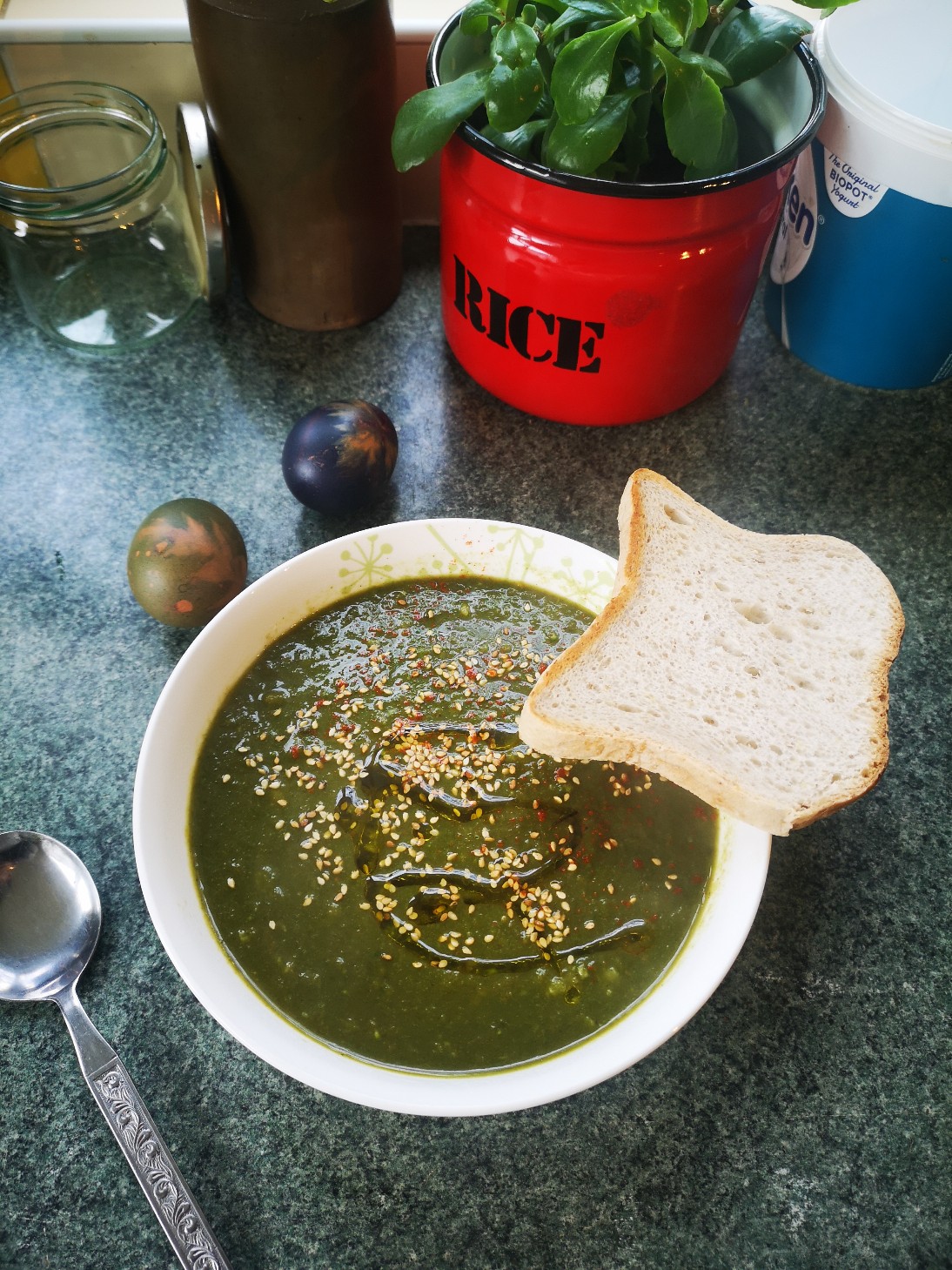 nettle soup in a white dish with a slice of bread