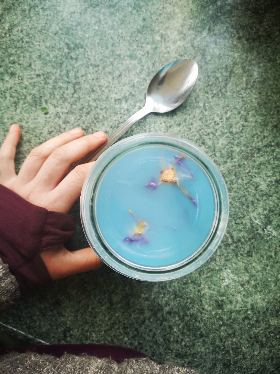 a hand next to a cbd-infused drink on a tabletop