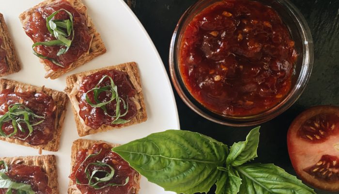 tomato balsamic jam in a jar and on crackers on a plate