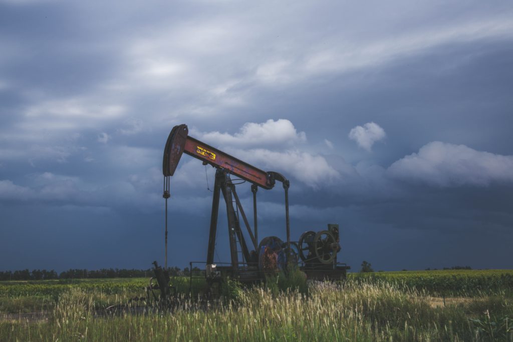 Oil pump in a field with a stormy sky in the background