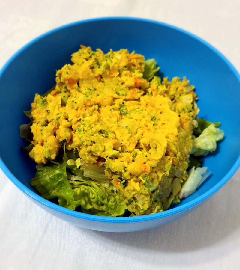 Vegan chickpea salad in a blue bowl against a white background