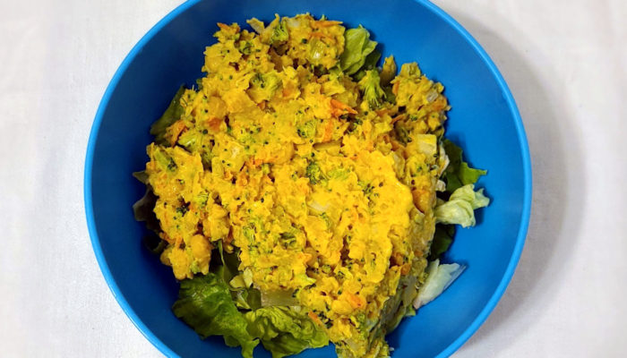 Vegan chickpea salad in a blue bowl with a white background