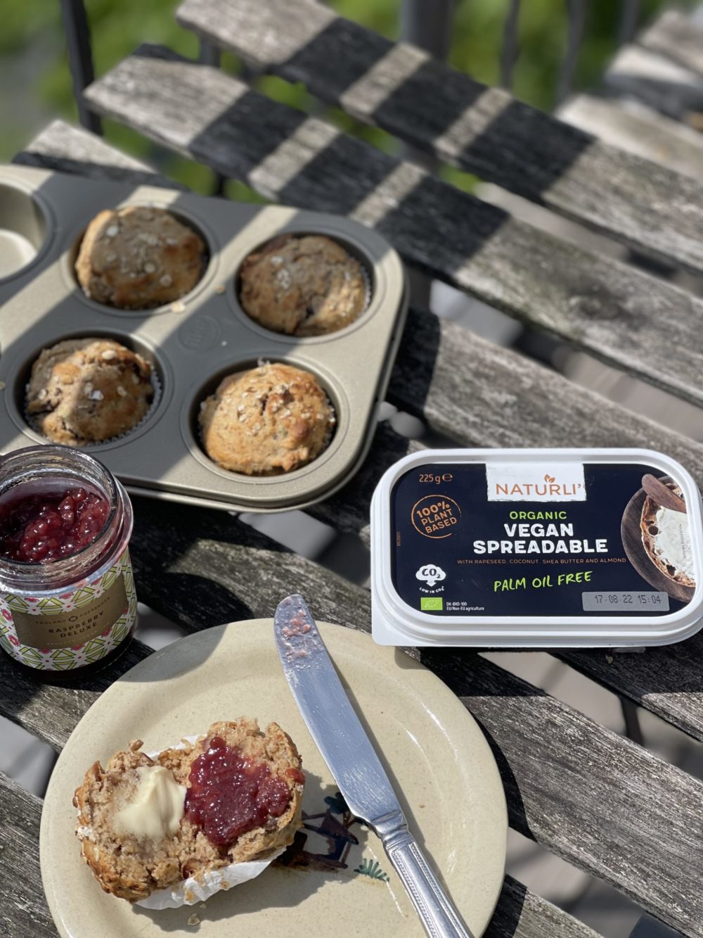 vegan muesli muffins with jam and vegan spread on a wooden table