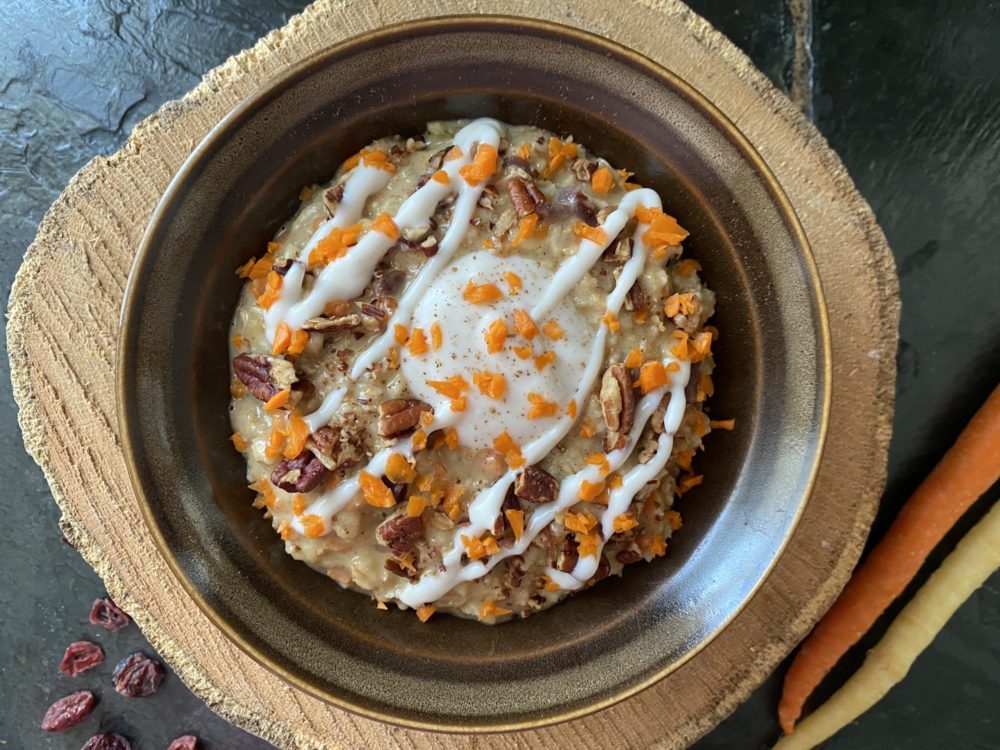vegan carrot cake oatmeal in a brown dish against a brown and black background