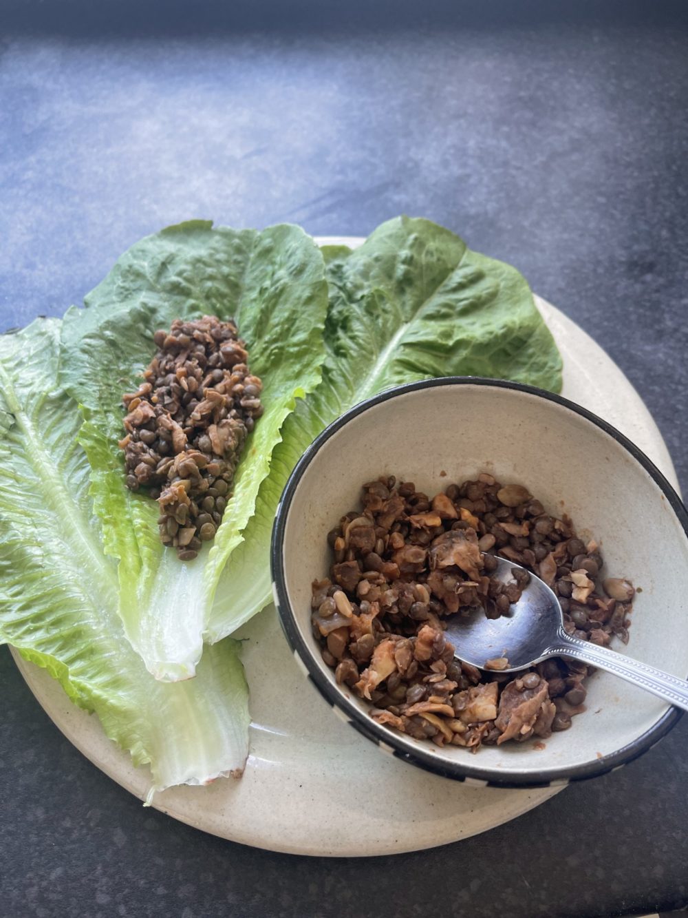 lentil walnut vegan meat on a white plate against a brown background