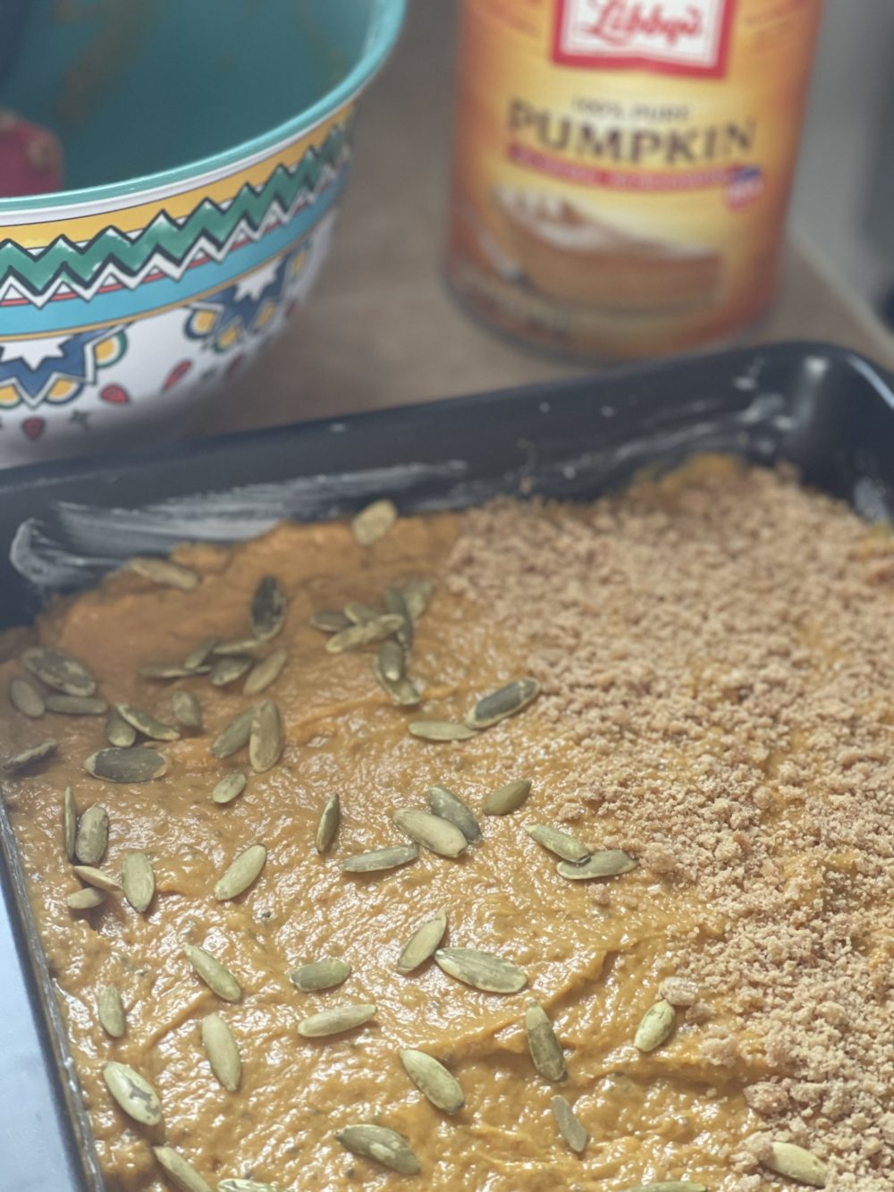 pumpkin tray cake next to a can of pumpkin and colorful dish