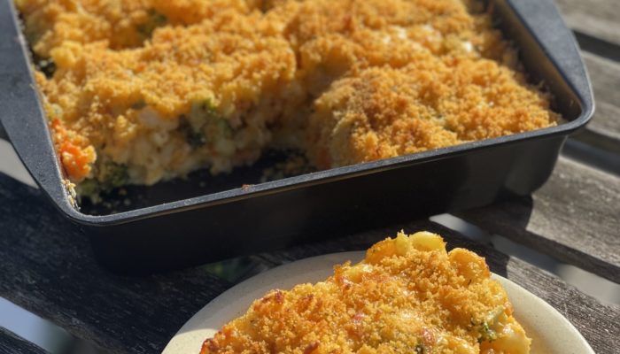 a serving of vegan macaroni and cheese on a plate next to a pan of food